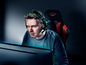 Ein Gamer mit Headset und einem DXT-Gaming-Stuhl vor einem Computer.
