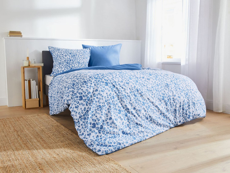 Ein Bett mit einer blauen und weißen Leopardendecken-Garnitur.