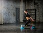 Eine Frau trainiert mit Reebok Fitness Steps in einem industriellen Raum.