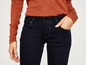 Dunkelblaue Skinny Jeans mit einem orangen Pullover.
