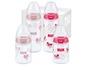 Vier NUK Babyflaschen mit Herz- und Schmetterlingsmotiven.