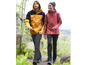 Mann und Frau tragen Outdoor-Jacken und Wanderhosen beim Wandern.