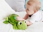 Ein Baby spielt mit einer grünen Frosch-Nachtlampe.
