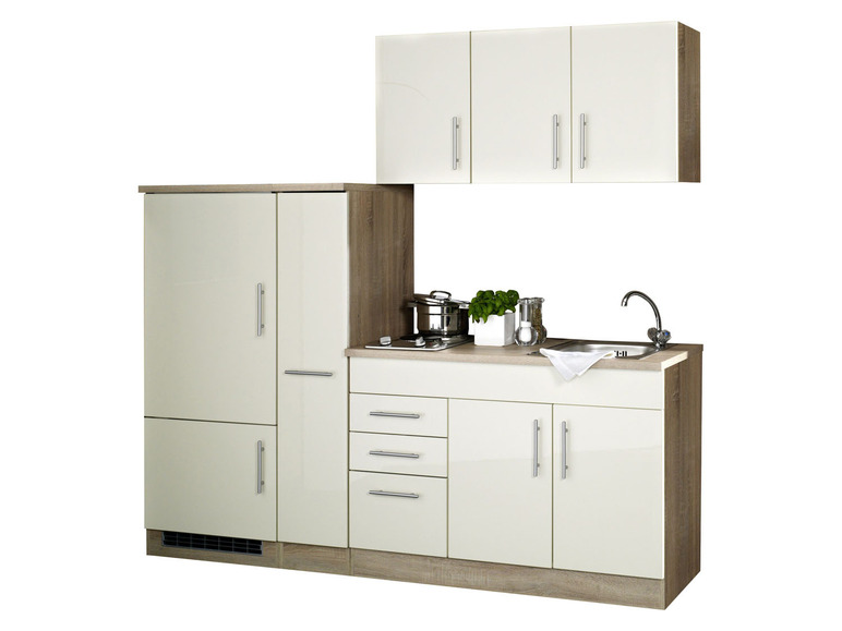 Küche mit Kühlschrank, Spüle und Schränken.