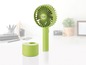 Ein grüner tragbarer Ventilator von Unold mit Ladestation.