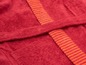 Nahaufnahme eines roten Bademantels mit orangenen Streifen.