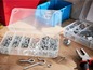 Schrauben, Haken und Kabelbinder in einer Aufbewahrungsbox.
