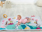 Baby auf einer Spielmatte mit Tiermotiven von Tiny Love.