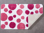 Eine rosa Badematte mit Punkten.