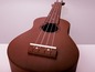 Eine braune Ukulele mit weißen Saiten