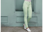 Eine Frau trägt hellgrüne Jeans und weiße Schuhe.