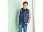 Ein Junge trägt eine Jeansjacke und Jeans.