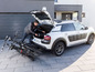 Ein Mann lädt zwei Fahrräder in den Kofferraum eines weißen Citroën C4 Cactus.