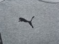 Ein grauer Pullover mit dem Puma-Logo.