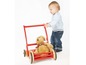 Ein Baby schiebt einen roten Lauflernwagen mit einem Stofftier.