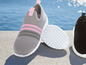 Graue und schwarze Slip-on Sneaker mit rosa Akzenten.