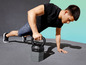 Ein Mann macht Liegestütze mit einer Kettlebell.