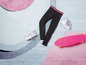 Schwarze Leggings, weiße Sneaker und ein rosa Skateboard.