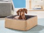 Ein Hund liegt in einem Hundebett mit Jute-Außenhülle und grauem Fleece-Innenfutter.