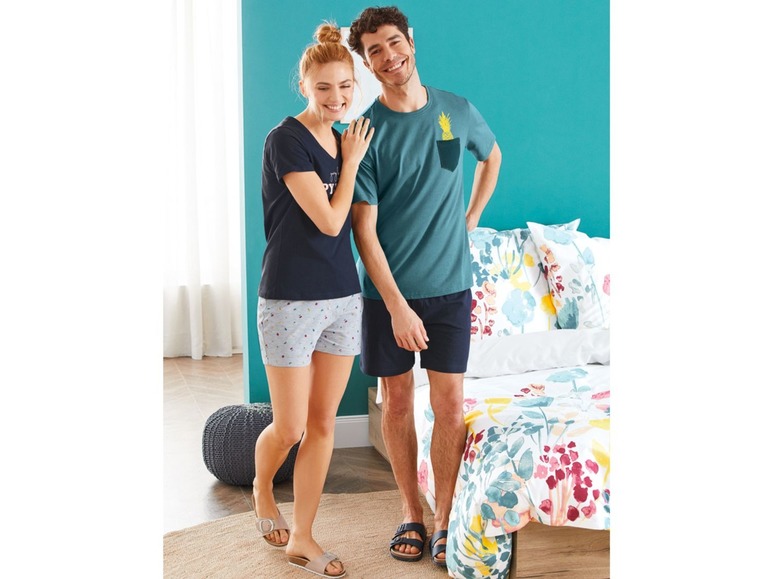 Ein Paar im Schlafanzug, die Frau in Shorts und der Mann in einem T-Shirt mit Ananas.