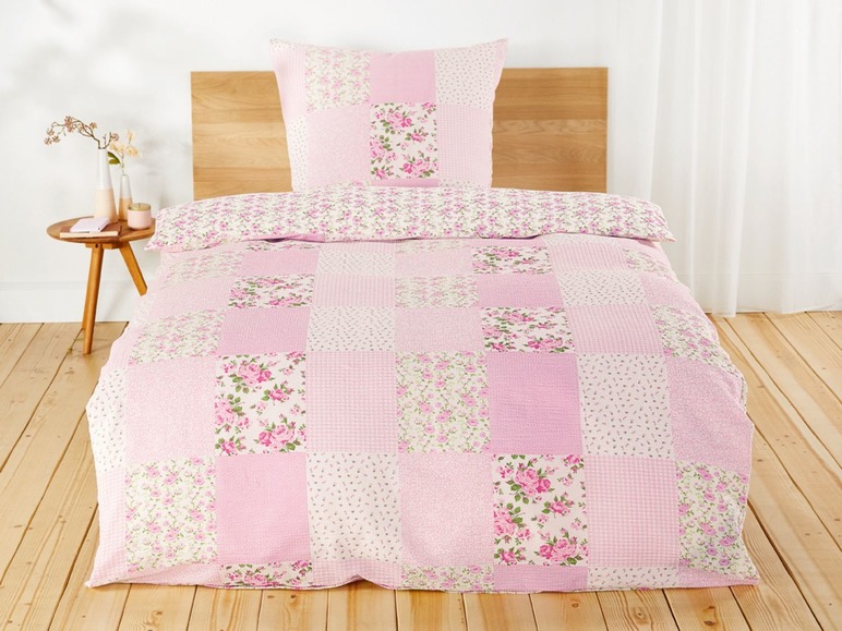 Ein rosa Bettbezug mit Blumenmuster im Patchwork-Stil.
