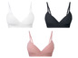 Drei nahtlose BHs in Weiß, Schwarz und Rosa.