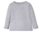 Ein graues Langarmshirt für Babys mit Rüschen an den Ärmeln.