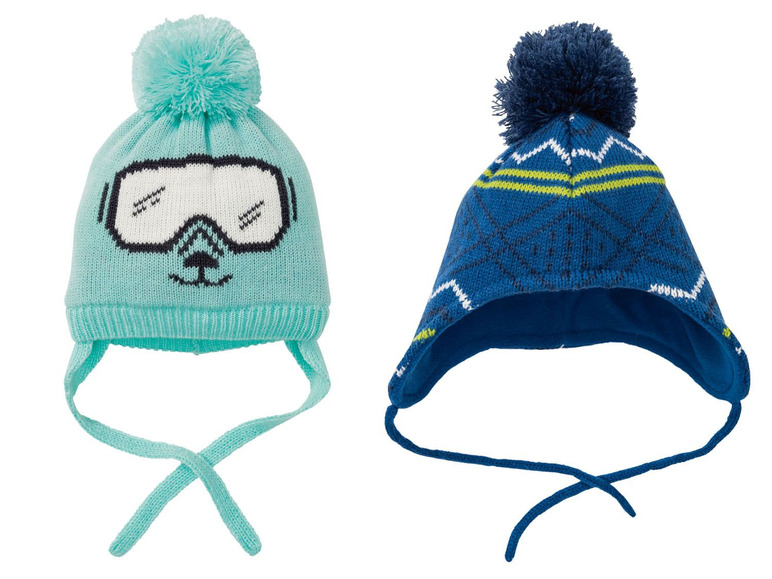 Zwei gestrickte Mützen mit Bommel, eine mit Skibrille-Druck.