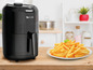 Eine schwarze Tefal Fritteuse mit einem Teller Pommes.