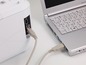 Ein Drucker, der über ein USB-Kabel an einen Laptop angeschlossen ist.