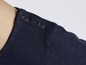 Detail eines dunkelblauen T-Shirts mit Knöpfen.