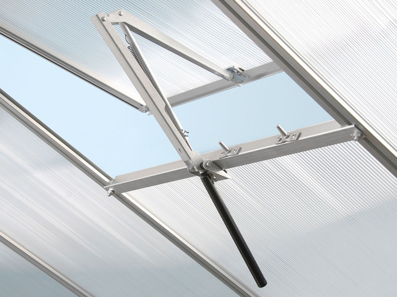 Ein automatisches Dachfenster mit einer Stange und einem Federmechanismus in einem Gewächshaus.