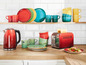Ein roter Wasserkocher, ein roter Toaster und Geschirr in verschiedenen Farben.