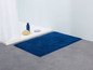 Eine blaue Badezimmermatte im Badezimmer.