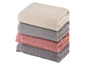 Stapel Handtücher in Beige, Grau und Rosa.