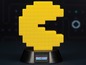 Eine gelbe Pac-Man Lampe auf einem schwarzen Sockel.