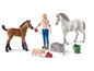 Eine Pferdefigur, ein Fohlen und ein Schwein mit einem Veterinär-Spielset.