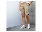 Mann trägt beige Cargo Shorts und weiße Sneaker.