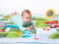 Baby auf einer Spielmatte von Tiny Love mit verschiedenen Texturen und Mustern.
