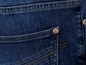 Detail einer Jeanshose mit einer kleinen Tasche und einem Markenzeichen