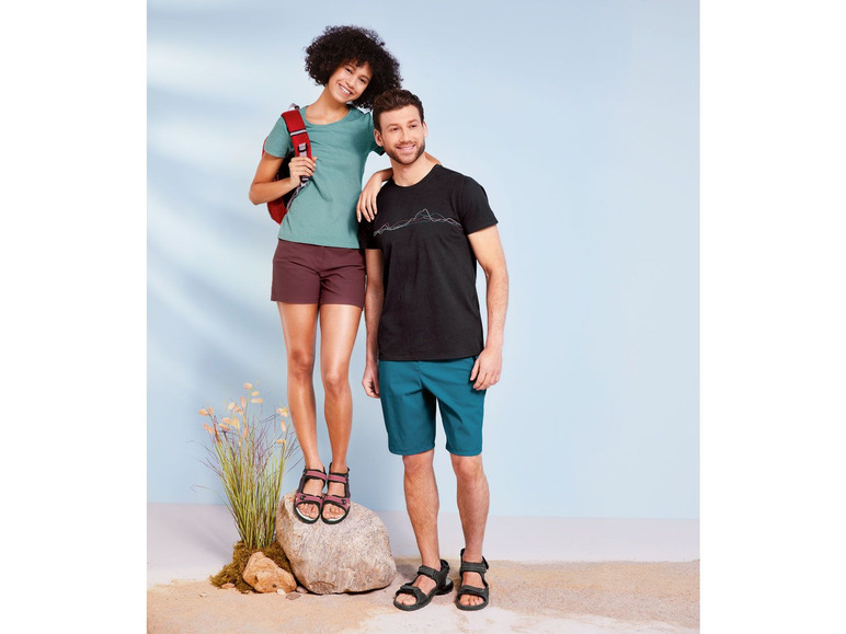 Ein Mann und eine Frau in Shorts und Sandalen, mit einem Rucksack.