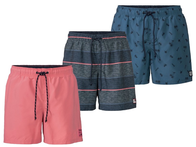 Drei Badehosen mit tropischen Prints, darunter Streifen und Palmen.