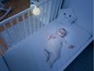 Ein Baby in einem Kinderbett mit Nachtlicht und Plüschtier