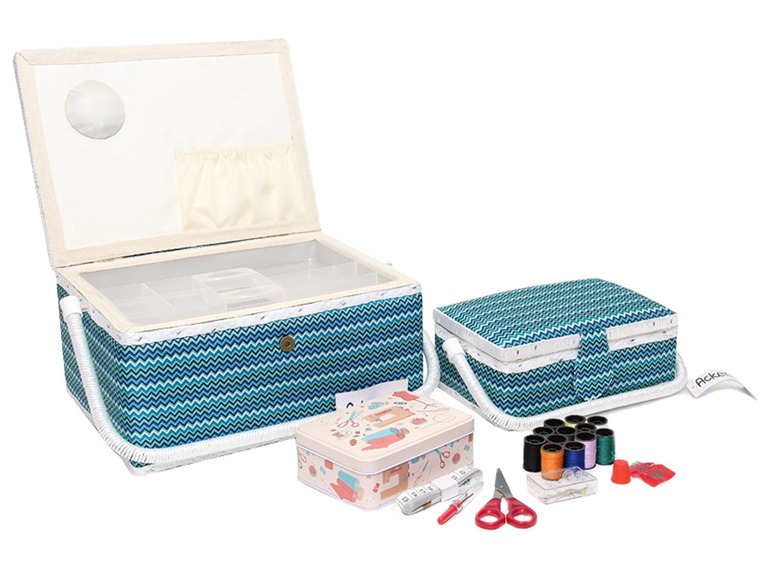 Zwei blaue Nähkästen mit Zickzack-Muster, eine Blechdose und Nähzubehör.