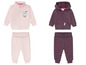 Zwei Baby Jogginganzüge, ein rosa mit einem Igel und ein dunkelvioletter mit dem Schriftzug '2 Cute'.