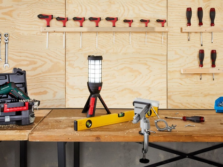 Ein Werkbank mit einer Parkside Bohrmaschine, einer Arbeitsleuchte und einem Schraubstock.