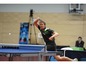 Ein Tischtennisspieler in Aktion während eines Spiels mit einem Donic-Schläger.
