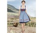Eine Frau trägt ein blaues Dirndl mit weißen Blumen.