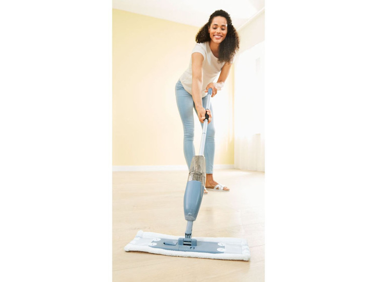 Eine Frau reinigt den Boden mit einem Sprühmopp.