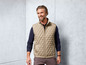 Mann trägt eine beige gesteppte Weste.